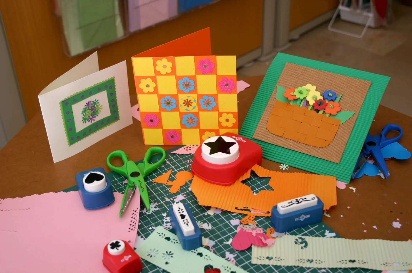 Handmade cards, shaped punches, scissors, and colourful papers on a Kağıt vs. project table.