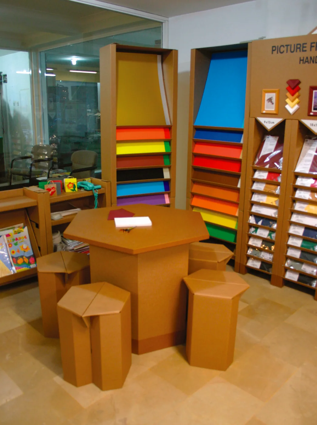 Colourful paper shelves with a cardboard table and stools inside a Kağıt vs. shop.